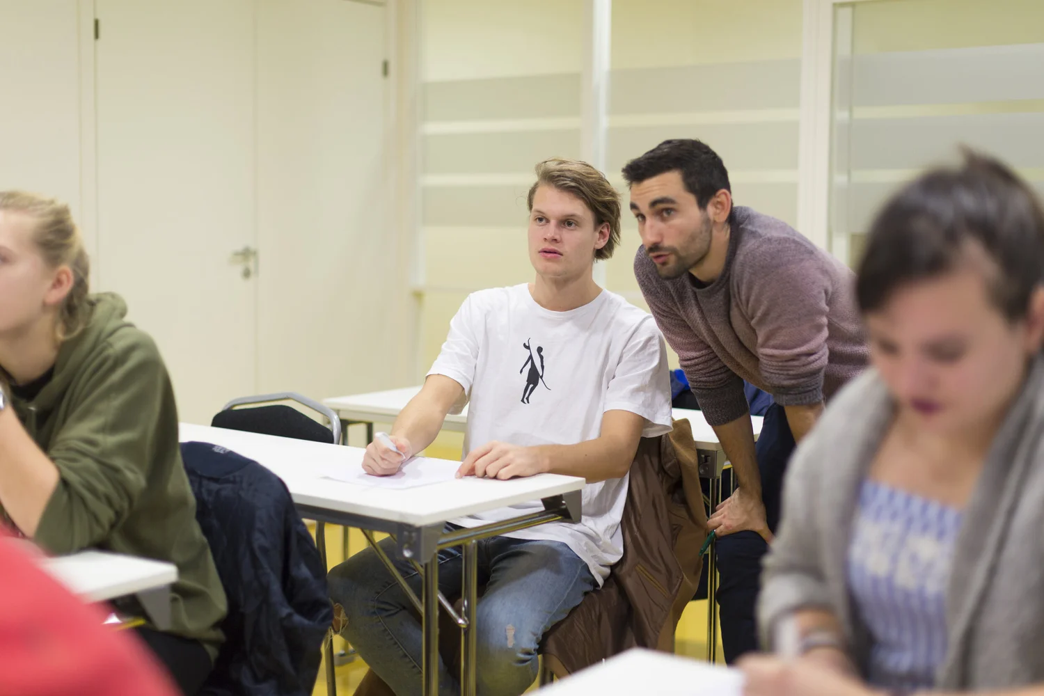 Karim hjelper en elev ved pulten